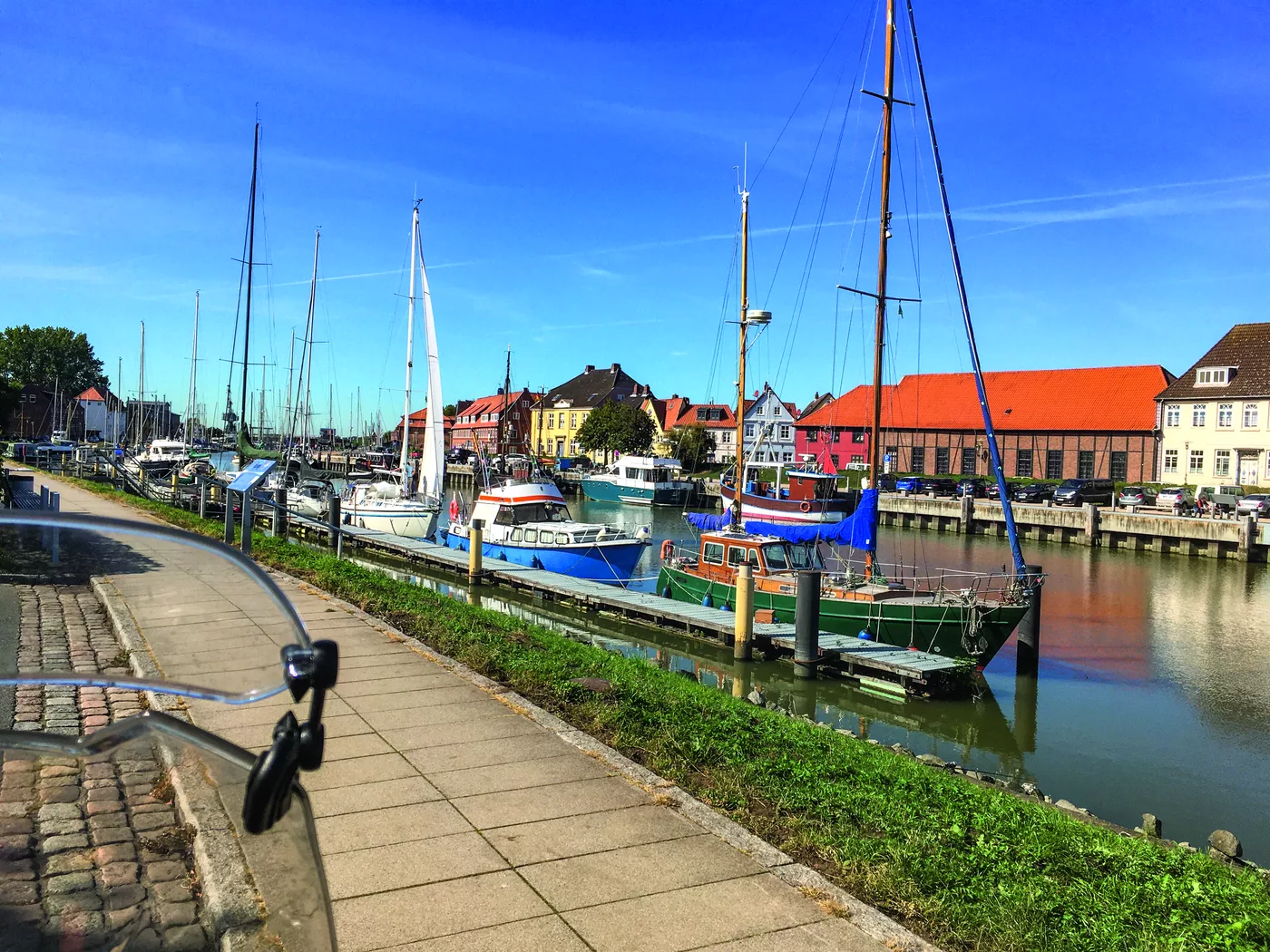 Segelboote im Hafenbecken vor Backsteinhäusern Segelboote im Hafenbecken vor Backsteinhäusern